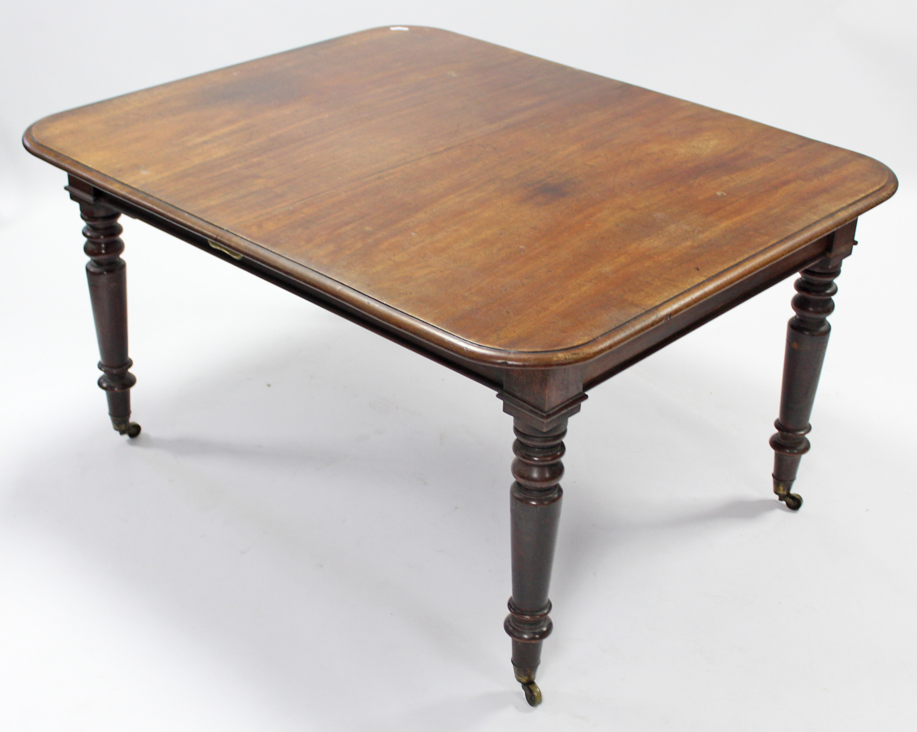 A Victorian mahogany extending dining table with rounded corners & moulded edge, on ring-turned