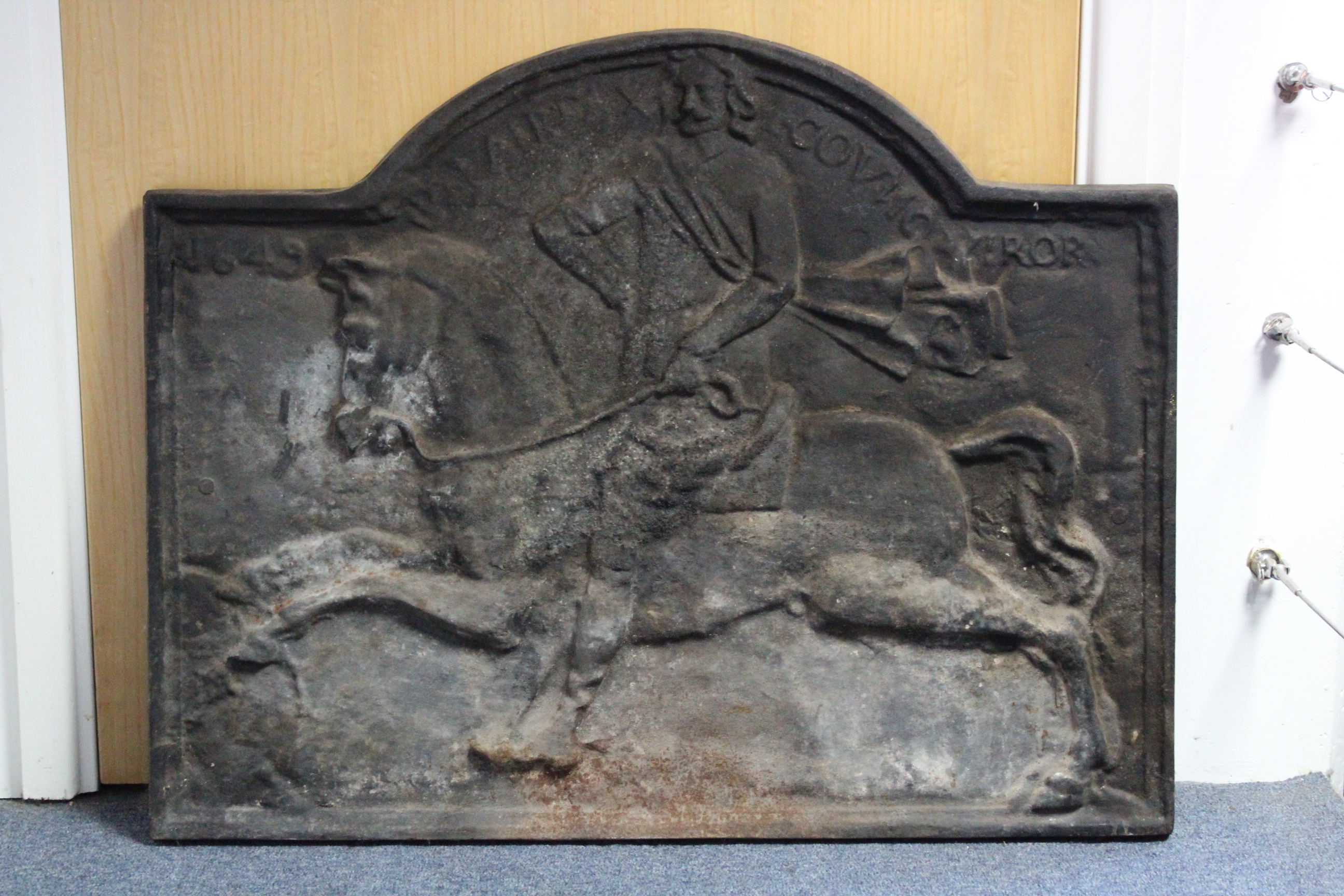 A 17th century-style cast-iron fireback with shaped top & scene of a man on horseback, dated 1649;