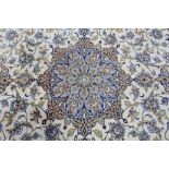 A Persian carpet of ivory & pale blue ground, with central medallion surrounded by floral spandrels,