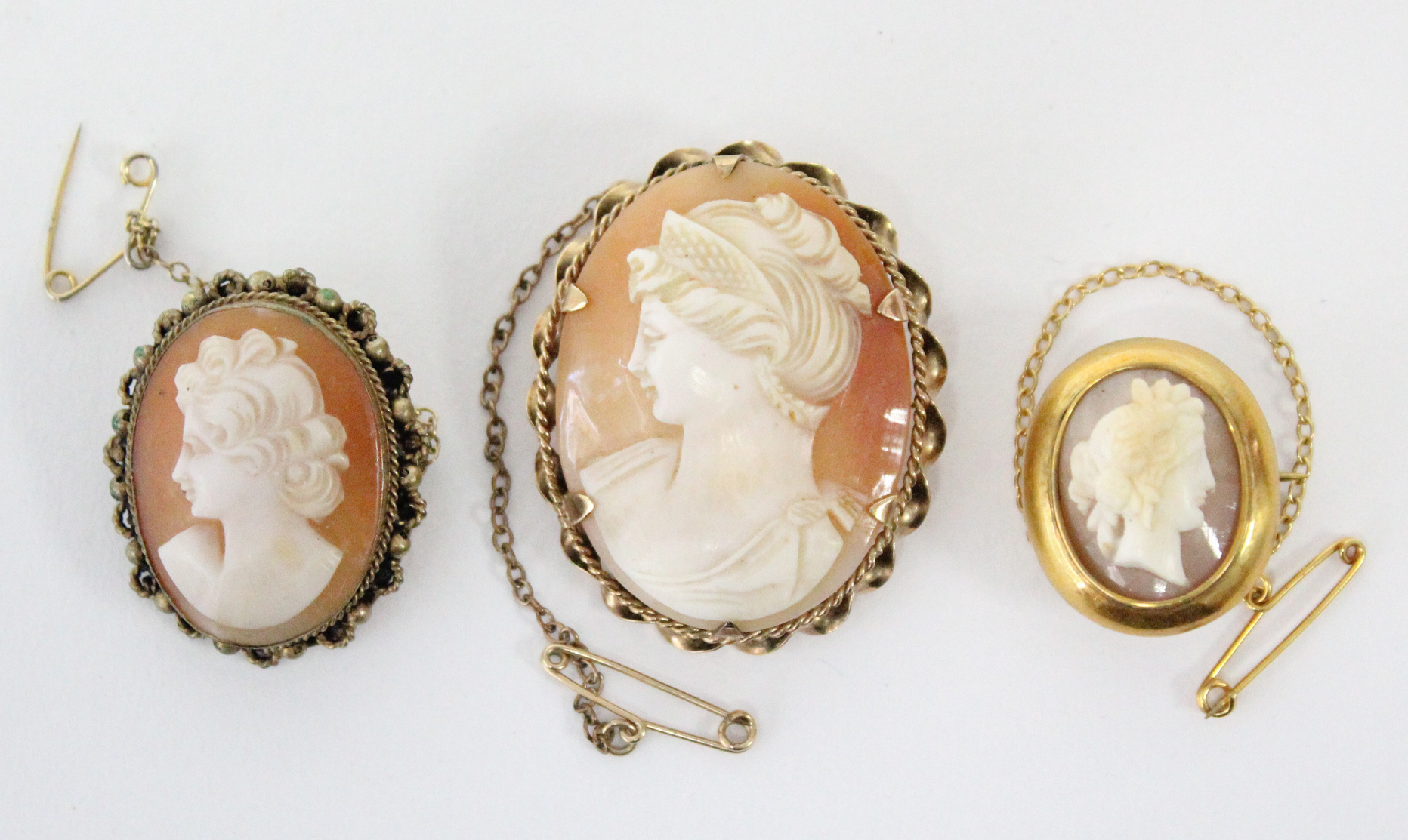 A carved shell oval cameo brooch depicting a female portrait, in 9ct. gold mount, 1½” x 1”; & two