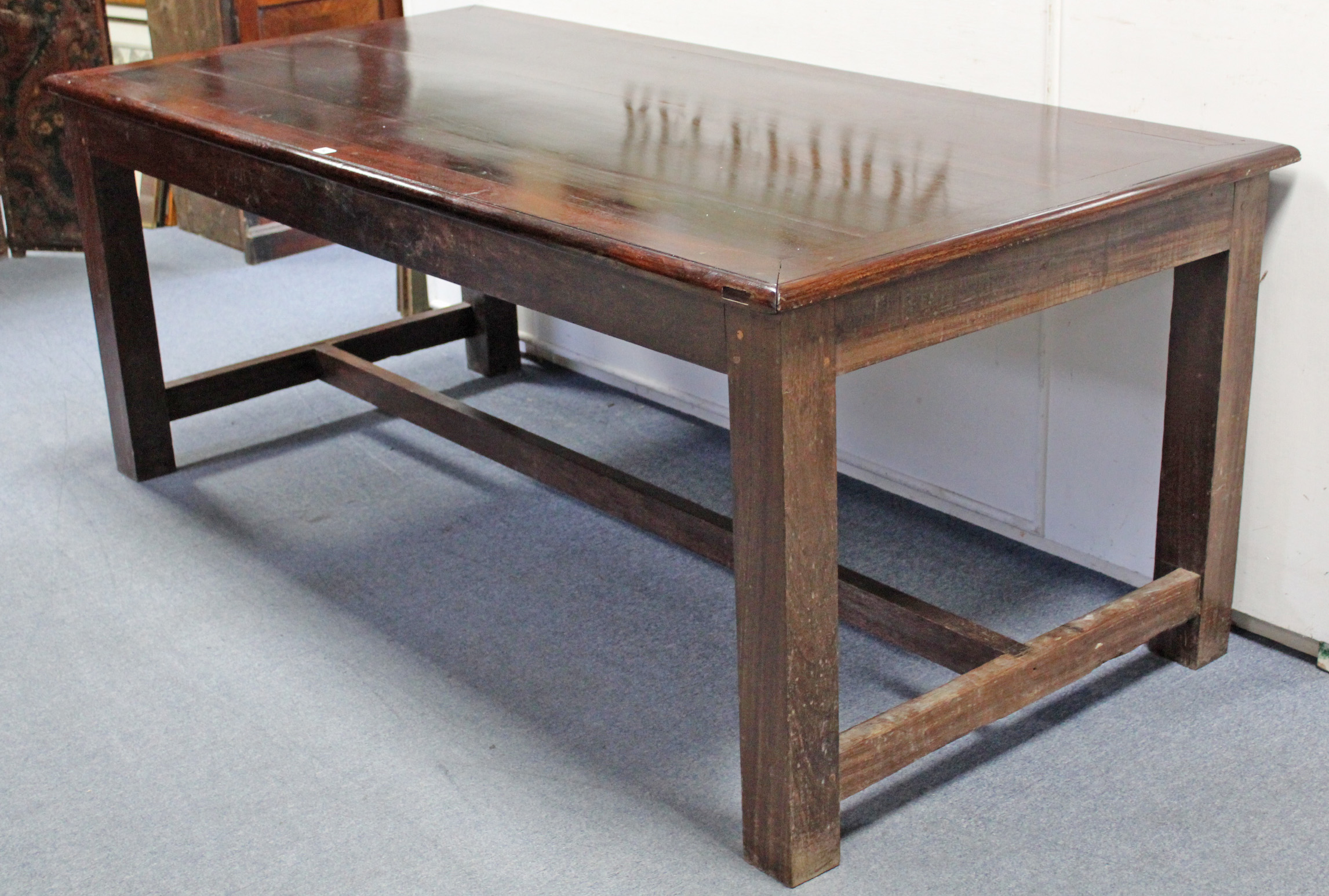 A teak dining table, the three-board rectangular top with cleated ends, on square legs