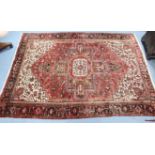 A Persian pattern carpet of crimson & ivory ground, with central cross motif surrounded by geometric