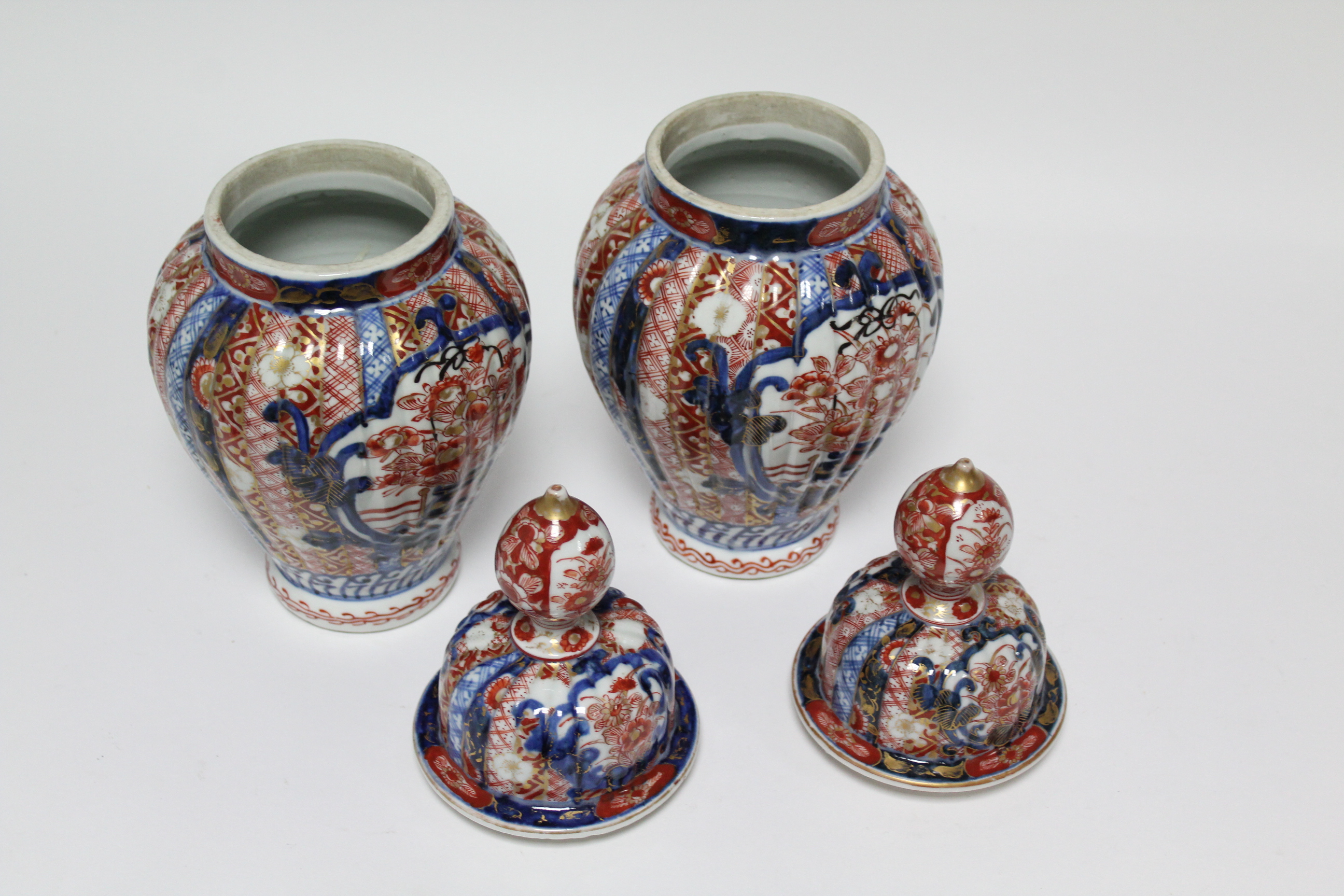 A pair of 19th century Japanese Imari fluted baluster vases with domed covers; 12” high. - Image 5 of 8