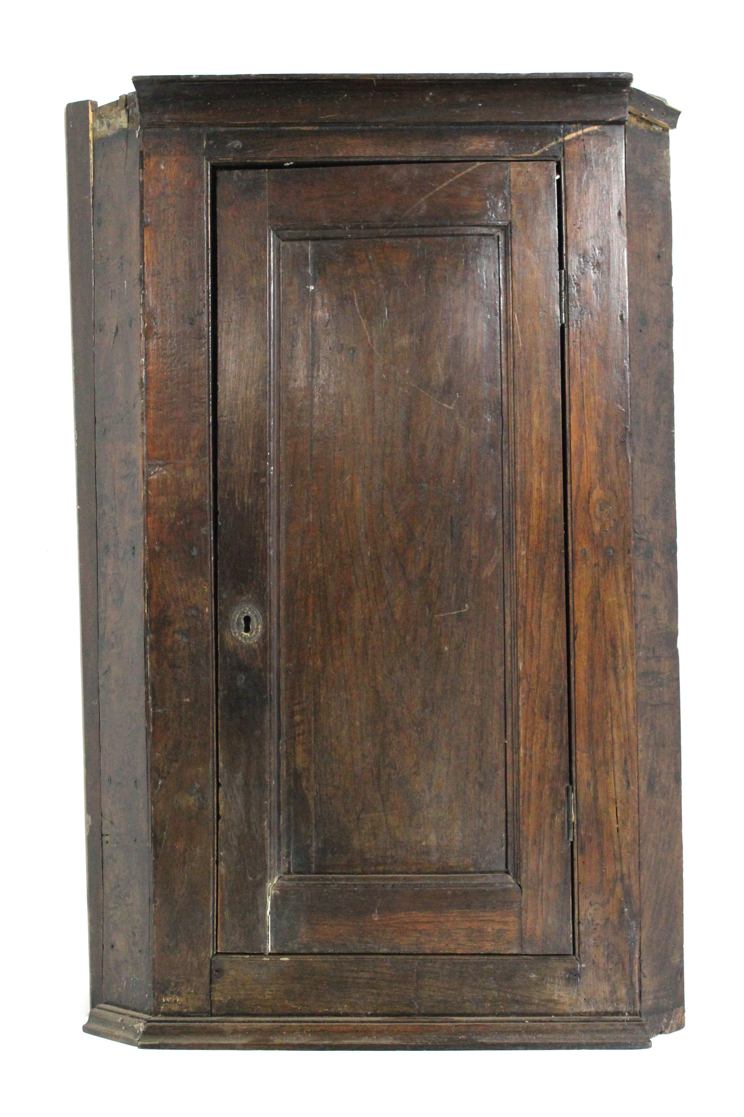 A late 18th century oak corner cupboard, fitted three shelves enclosed by a fielded panel door;