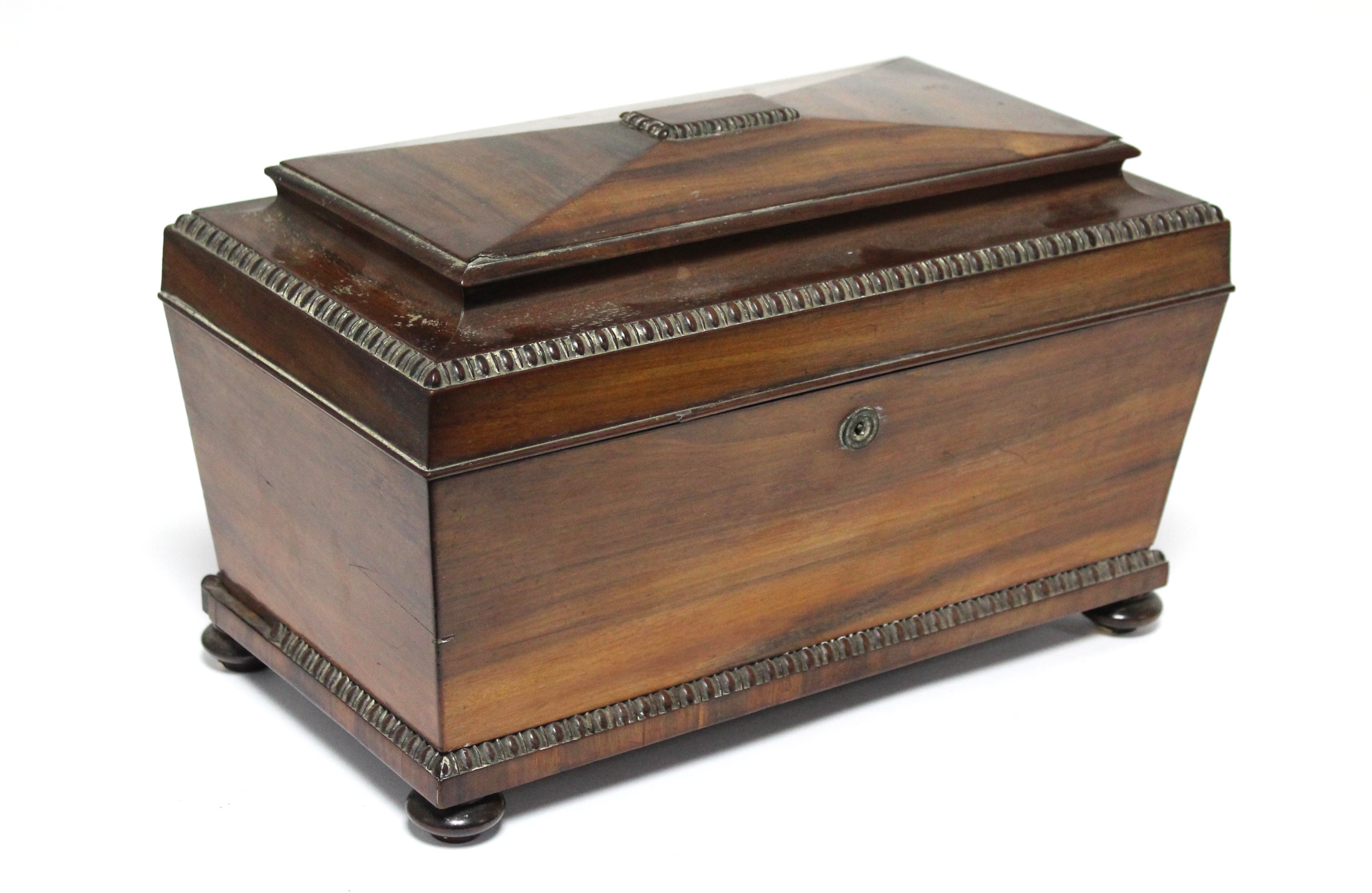 A regency Goncalo Alves tea caddy of rectangular tapered form with egg-&-dart decoration & fitted