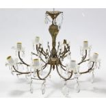 A gilt-metal eight branch chandelier with scroll arms & hung with prism drops, 26” wide x 18” high.