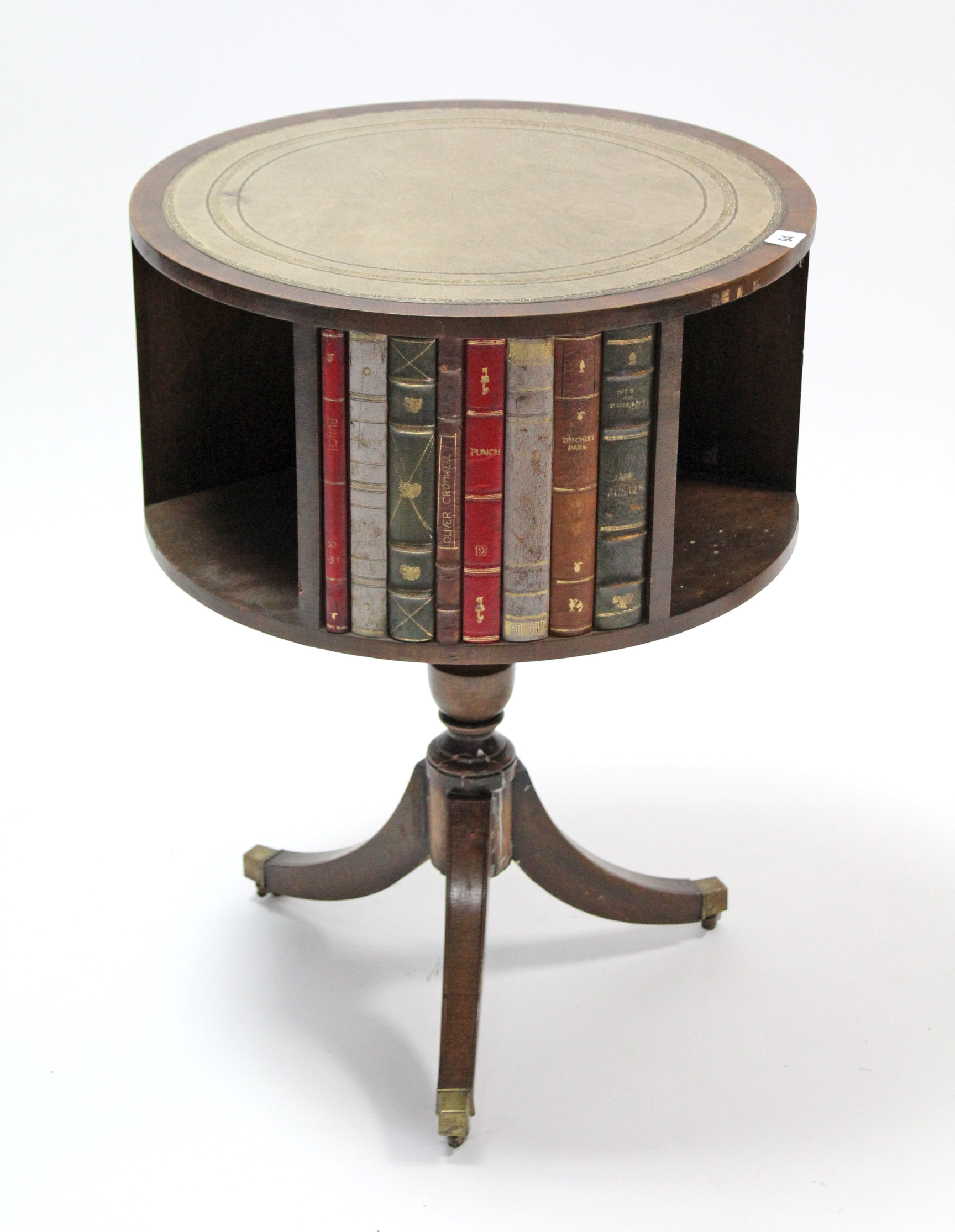 A reproduction mahogany book table inset gilt-tooled grey leather to the circular revolving top,