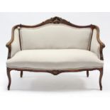 A continental-style carved beech frame two-seater settee upholstered cream material, & on short