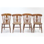 A set of four splat-back kitchen chairs with hard seats, & on turned legs with turned stretchers.