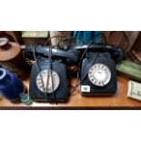 Two vintage black Bakelite telephones; a collector’s doll; a small wall cabinet; various glass