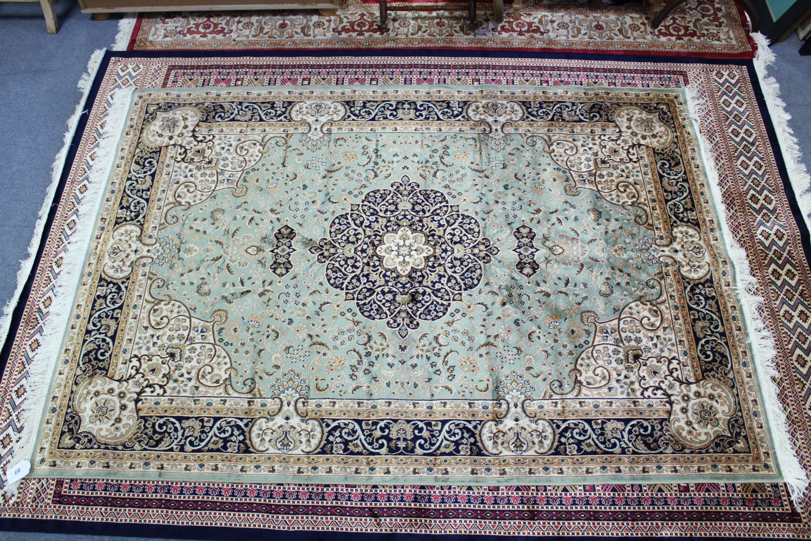 A Keshan carpet of pale green & deep blue ground & with all-over repeating multi-coloured