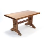 An Arts & Crafts-style walnut refectory table on carved end supports joined by pierced centre