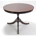 A reproduction mahogany circular pedestal dining table on vase-turned centre column & three splay