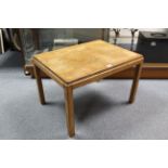 A Russell’s of Broadway teak coffee table on four square legs, 23¾” wide.