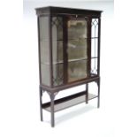 An Edwardian mahogany display cabinet with blind-fret cornice, glazed door & sides, fitted two