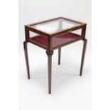 A walnut bijouterie table enclosed by glazed hinged lift-lid & glazed sides, & on square tapered