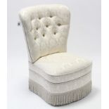 A reproduction buttoned-back nursing chair upholstered cream floral damask.