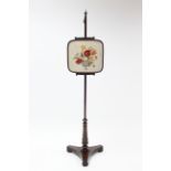 A 19th century rosewood pole banner screen with embroidered floral rise-&-fall panel, & on turned