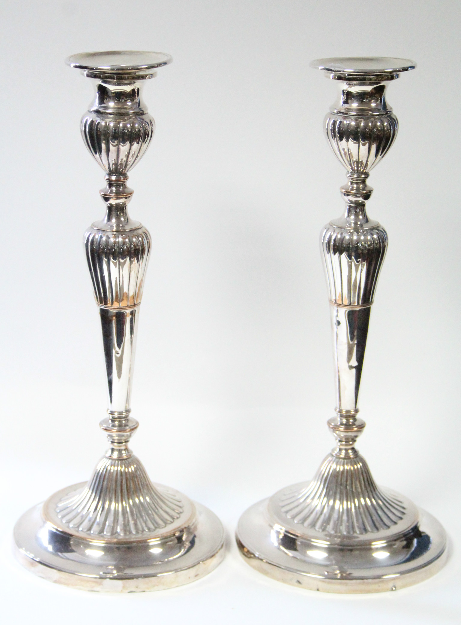 A pair of Sheffield candlesticks with part-reeded tapered columns on circular bases; 12½” high.