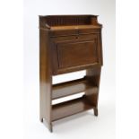 A 1930’s oak tray-top bureau with fitted interior enclosed by fall-front above two open shelves, 29”