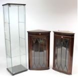A shop’s tall glazed display cabinet with one adjustable shelf, 64¼” high; together with two