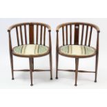 A pair of Edwardian inlaid-mahogany tub-shaped occasional chairs with padded oval seats, & on
