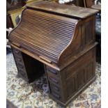 A late Victorian roll-top desk, with fitted interior enclosed by tambour shutter, fitted with an