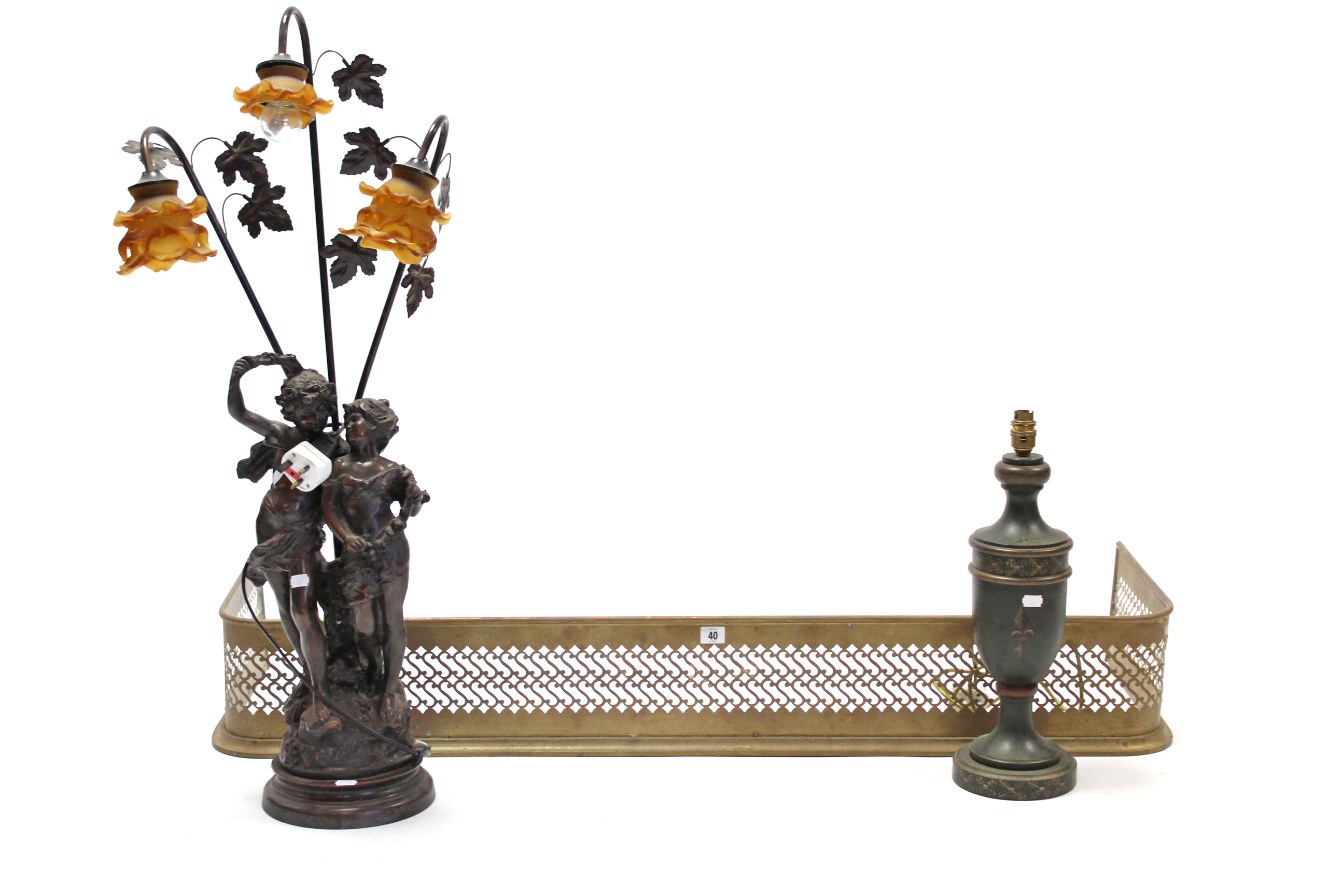 A brass fender with pierced frieze, 50” long; together with two table lamps.