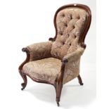 A Victorian carved mahogany-frame armchair with buttoned spoon-shaped back & sprung seat upholstered