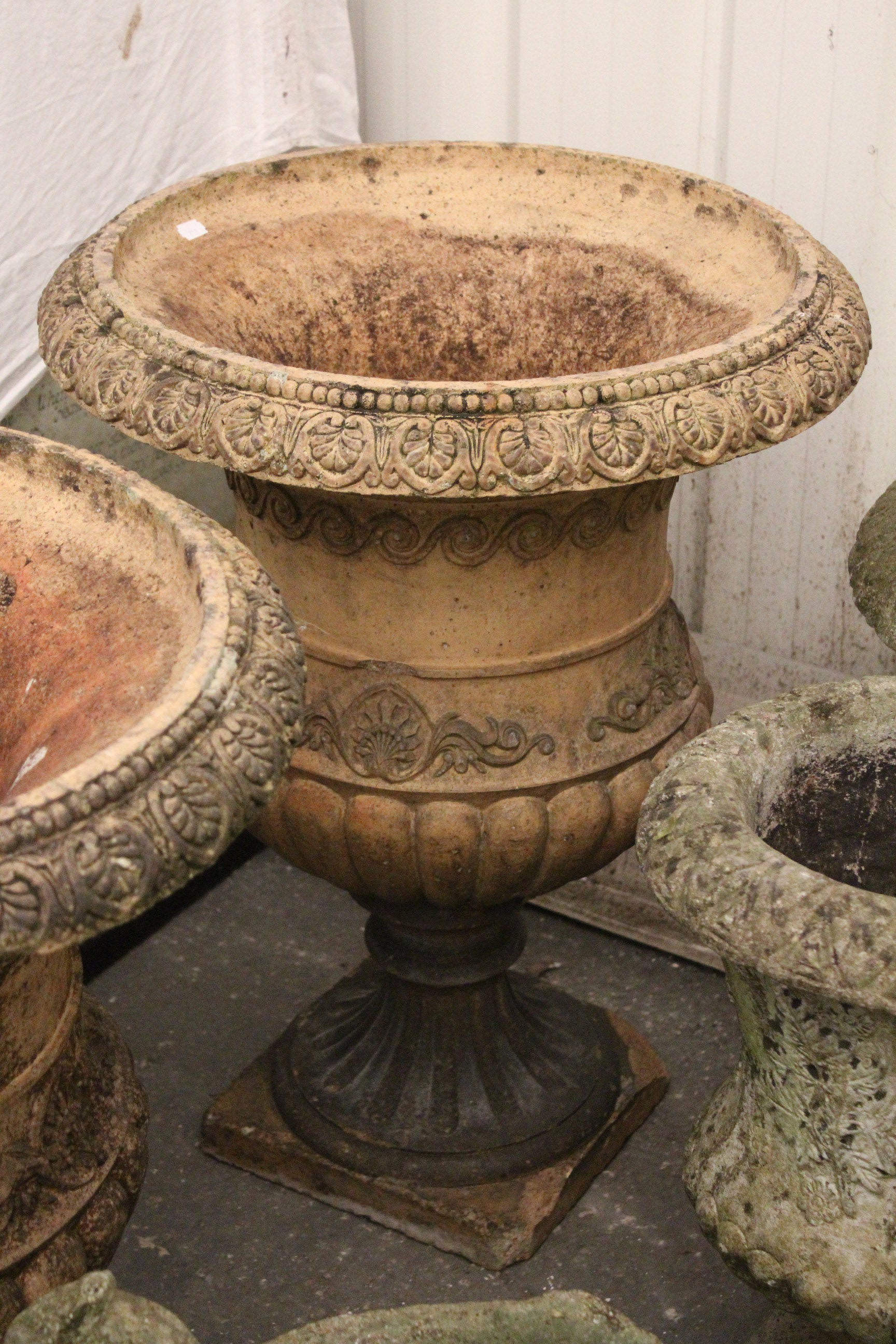 A pair of terracotta garden flower pots of ovoid form, with raised geometrical design, & on square - Image 3 of 3