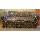 A Victorian chesterfield-style three seater settee upholstered floral material, & on turned feet