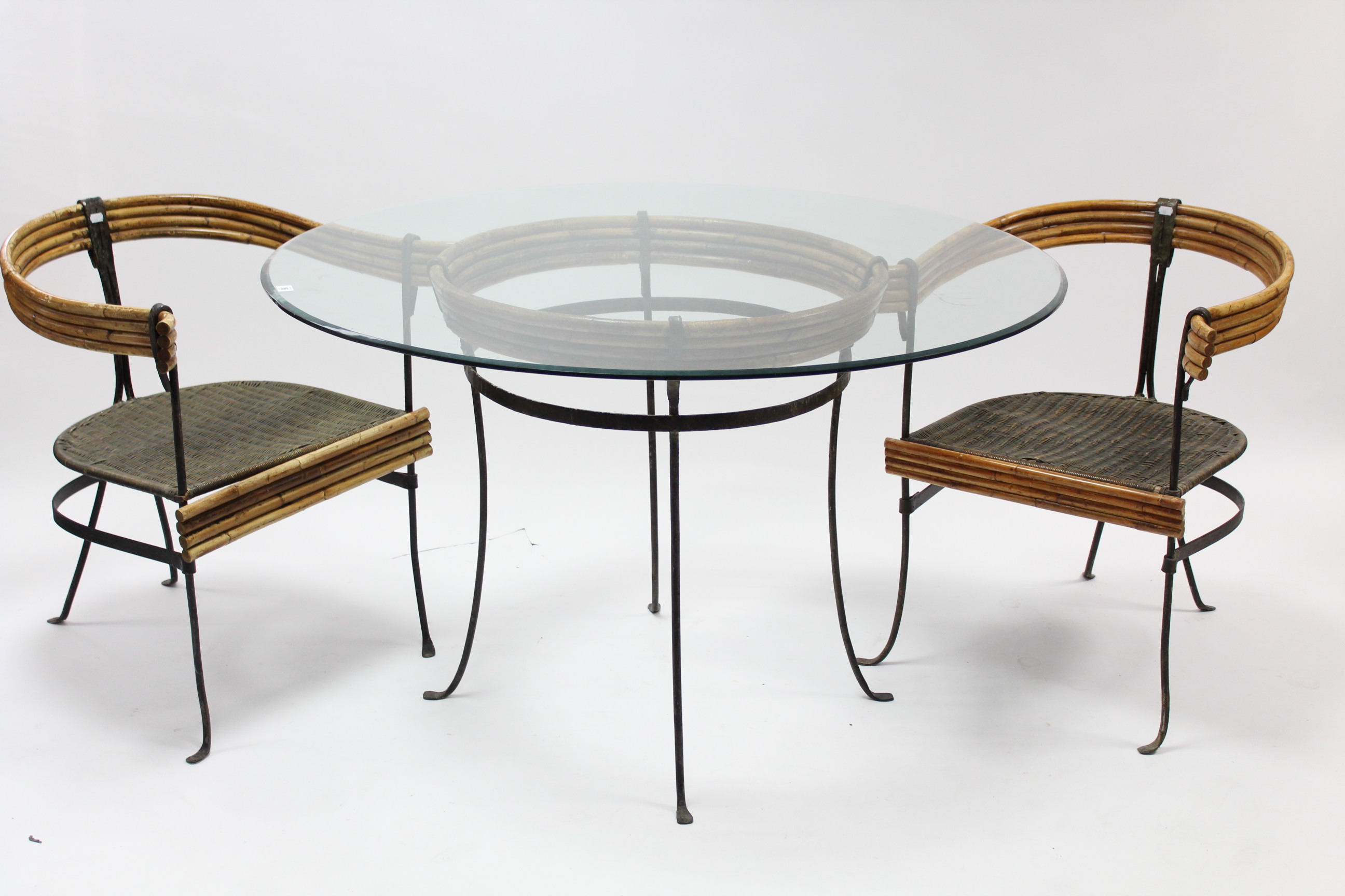 A cane & wrought-iron conservatory table on four shaped legs & with bevelled plate-glass top, 48”