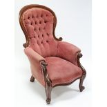 A mid-Victorian carved mahogany frame easy chair, the padded seat, arms & buttoned back