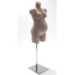 A mannequin in the form of a pregnant female, & on chrome-finish stand.