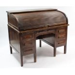 An early 20th century oak roll-top desk with fitted interior enclosed by tambour shutter, fitted