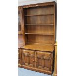 An Ercol light elm tall side unit the upper part fitted three open shelves, the base fitted two