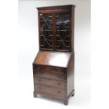 A reproduction mahogany bureau-bookcase, the upper part with three adjustable shelves enclosed by