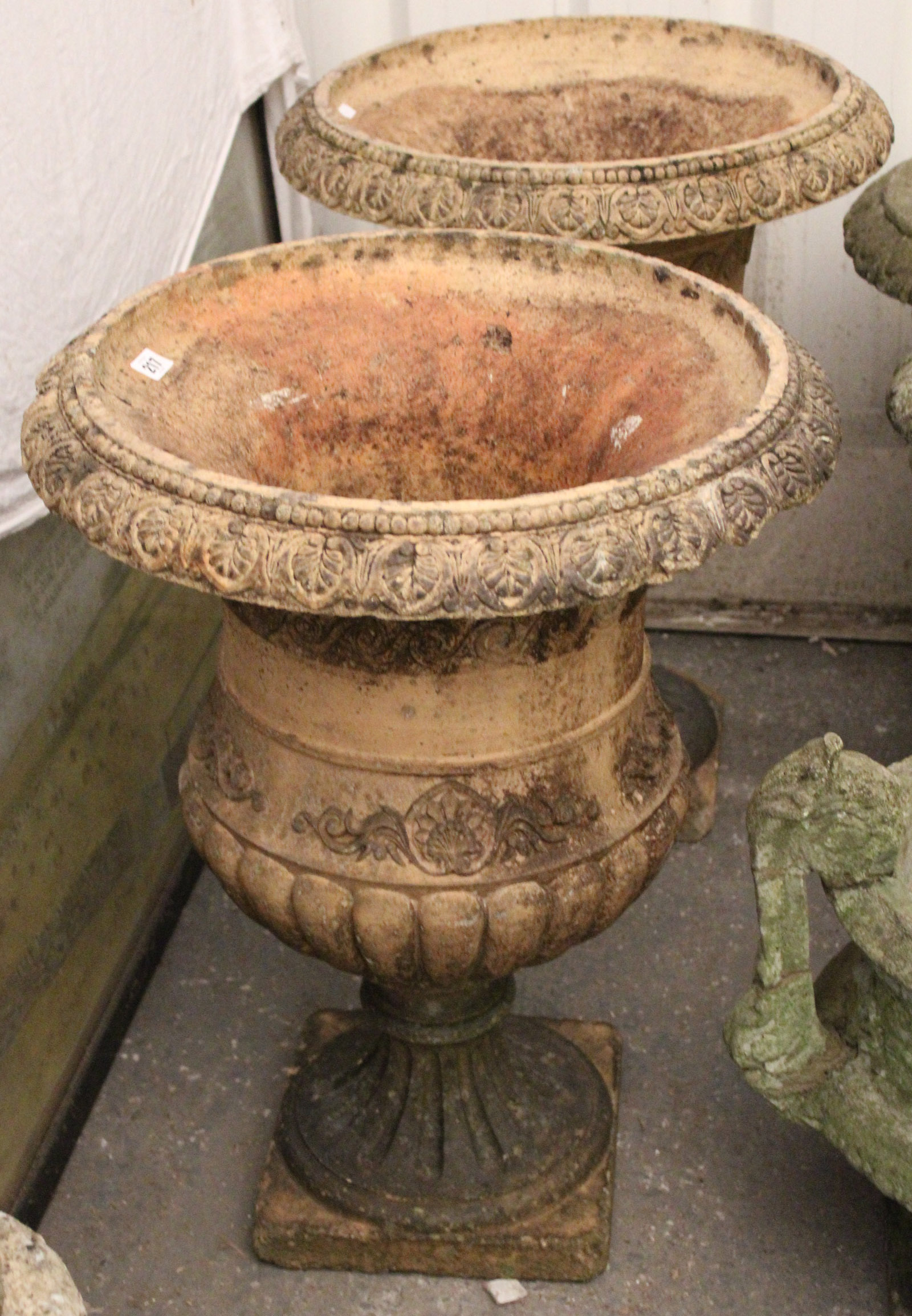 A pair of terracotta garden flower pots of ovoid form, with raised geometrical design, & on square - Image 2 of 3