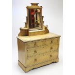 A Victorian grained pine dressing chest with rectangular bevelled swing mirror to the stage back,