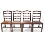 A set of four Georgian-style mahogany dining chairs with pierced ladder backs, padded drop-in-seats,