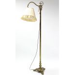 An Edwardian brass standard lamp with scroll arm, on triform base with lion paw feet; 5’6” high; & a