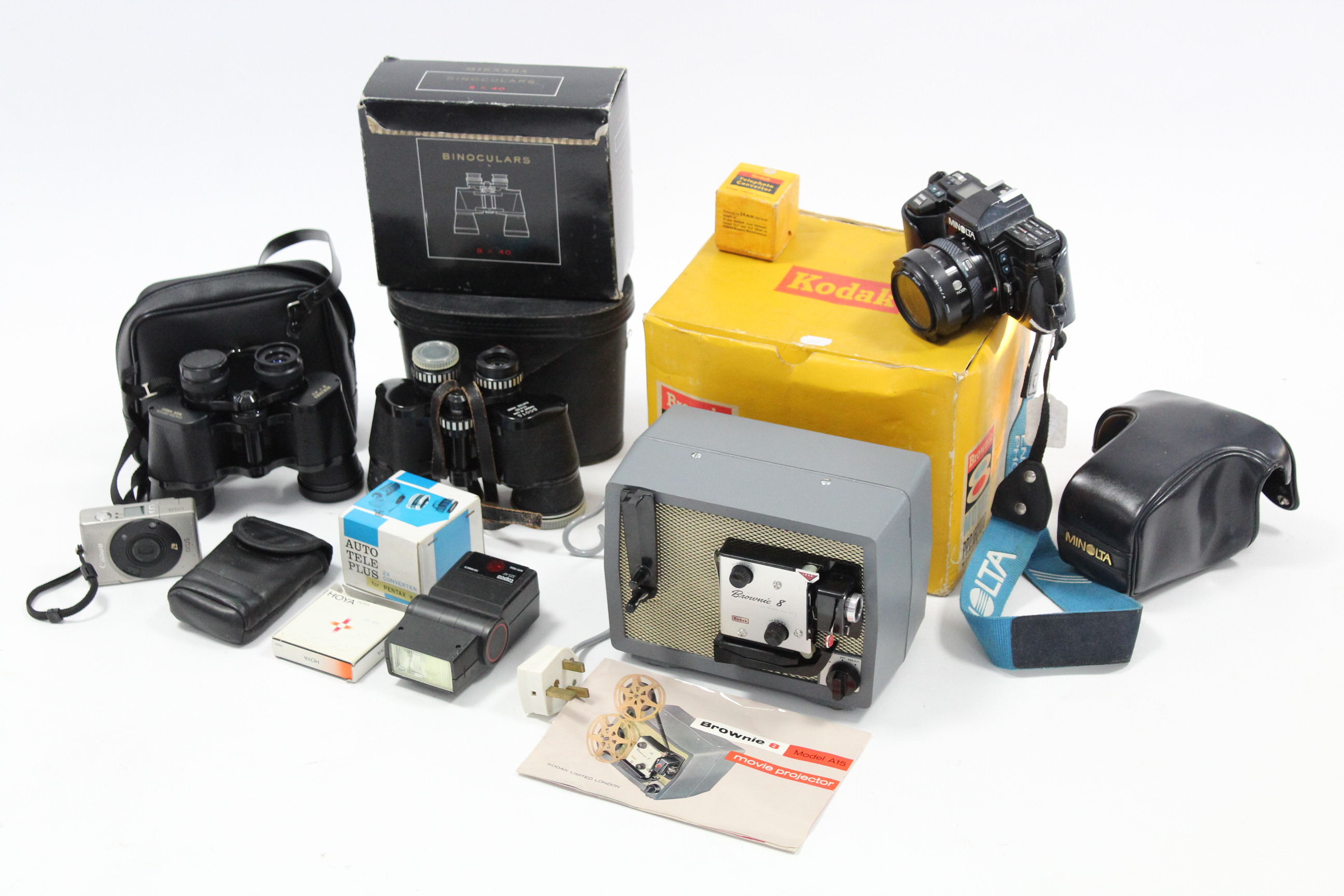 A Minolta “7000” camera with zoom lens; a Canon Ixus camera; a Kodak Brownie 8 movie projector; &