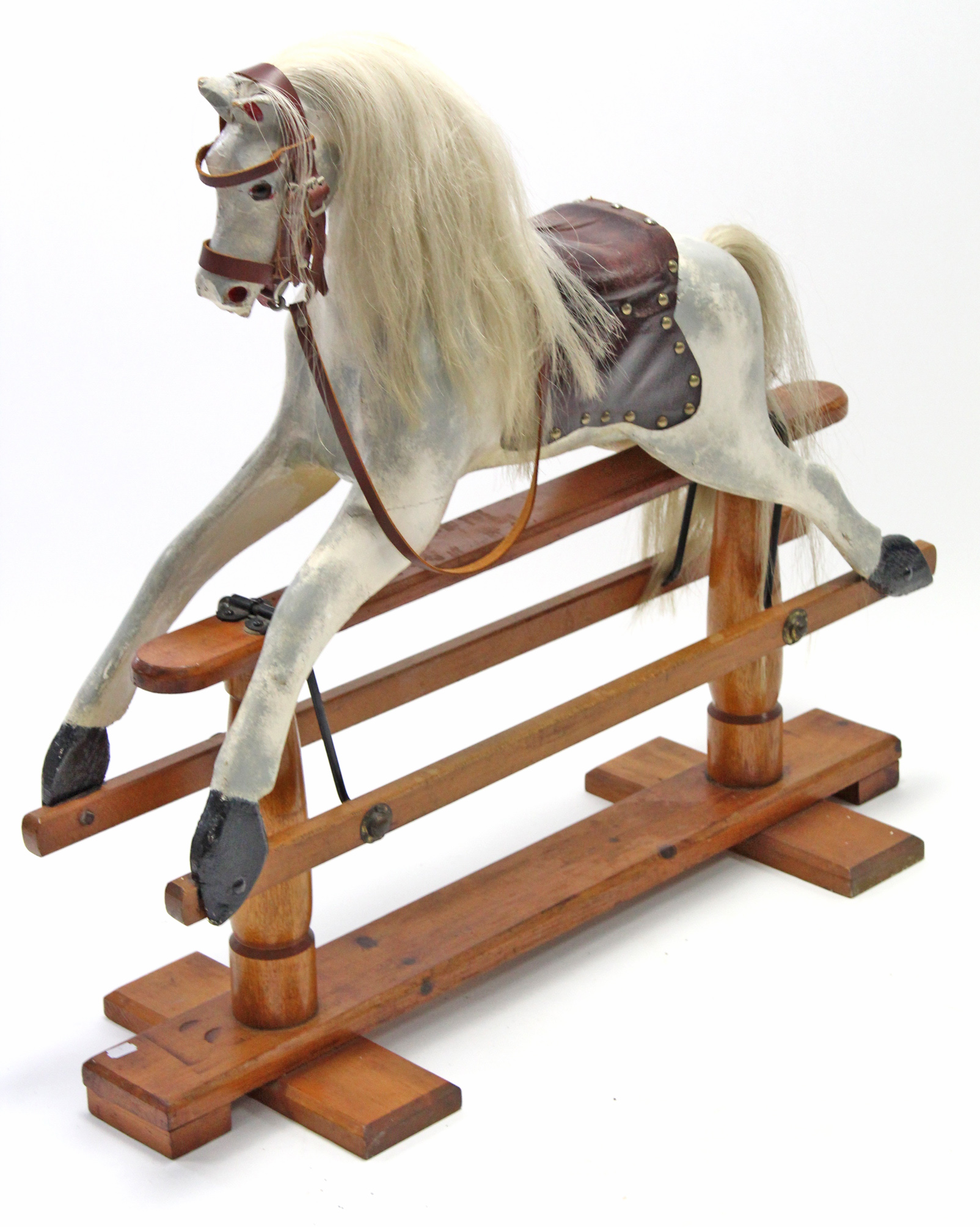 A dapple-grey painted wooden child’s rocking horse on pine trestle base, 34” long x 32” high.