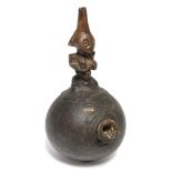 An African smoking pipe with short bowl to the round gourd body, with carved figural handle,