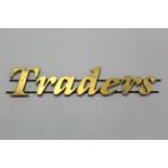 A gold-finish sign “TRADERS”, 46” LONG X 8½” HIGH.