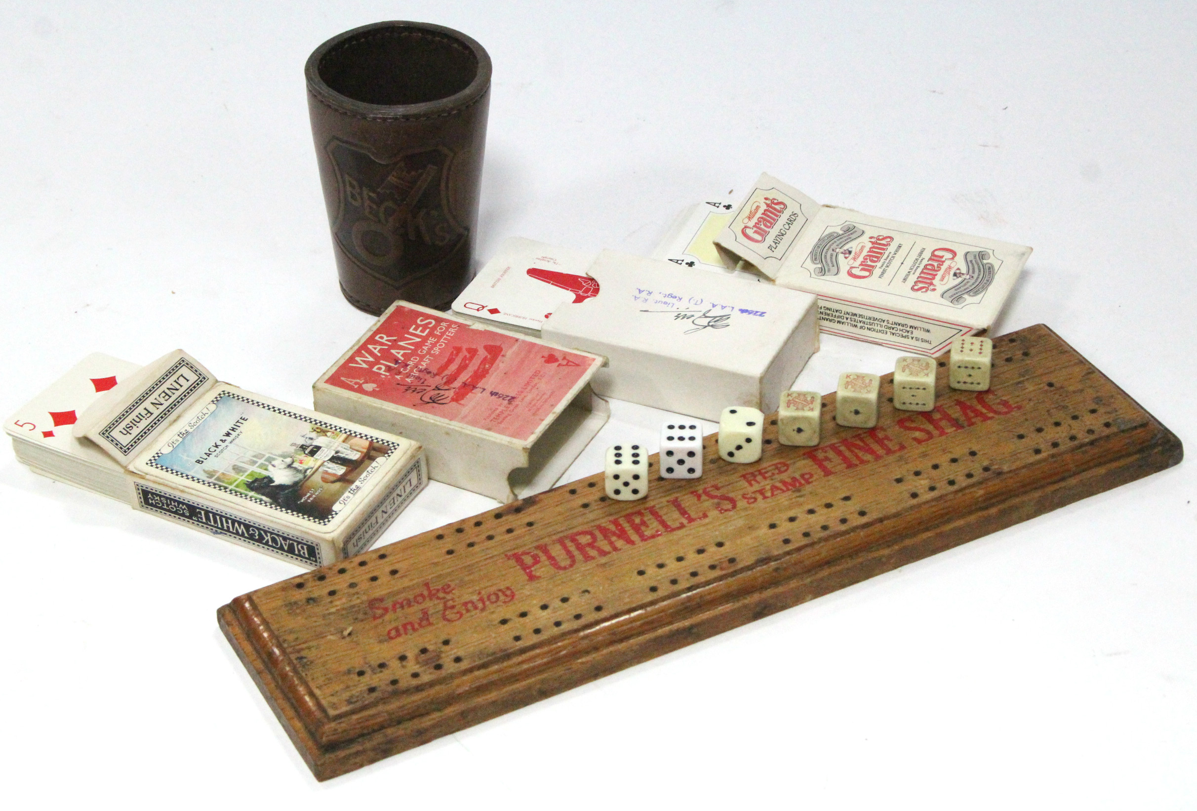 A “Purnells Red Stamp Fine Shag” a wooden cribbage board; three sets of playing cards; & a leather