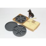 A carved wooden novelty inkwell in the form of a seated Doberman, 6” high; & two 16mm cine film