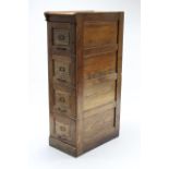 An early 20th century tall oak four-drawer filing cabinet with panelled side, 16” wide x 54” high.