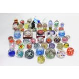 A collection of approximately forty various glass paperweights.