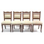 A set of four late Victorian dining chairs with padded backs & sprung seats, & on ring-turned